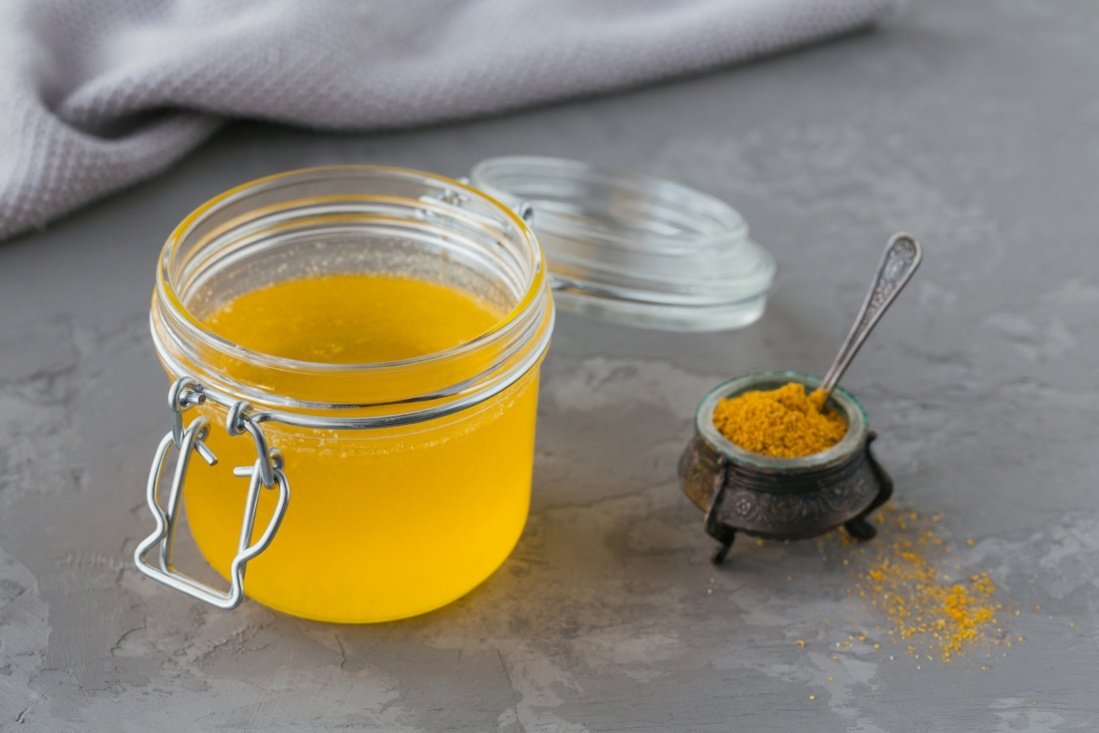 Turmeric and ghee superfood concept image showing turmeric roots and ghee jar, representing health benefits, anti-inflammatory properties and Ayurvedic nutrition focus